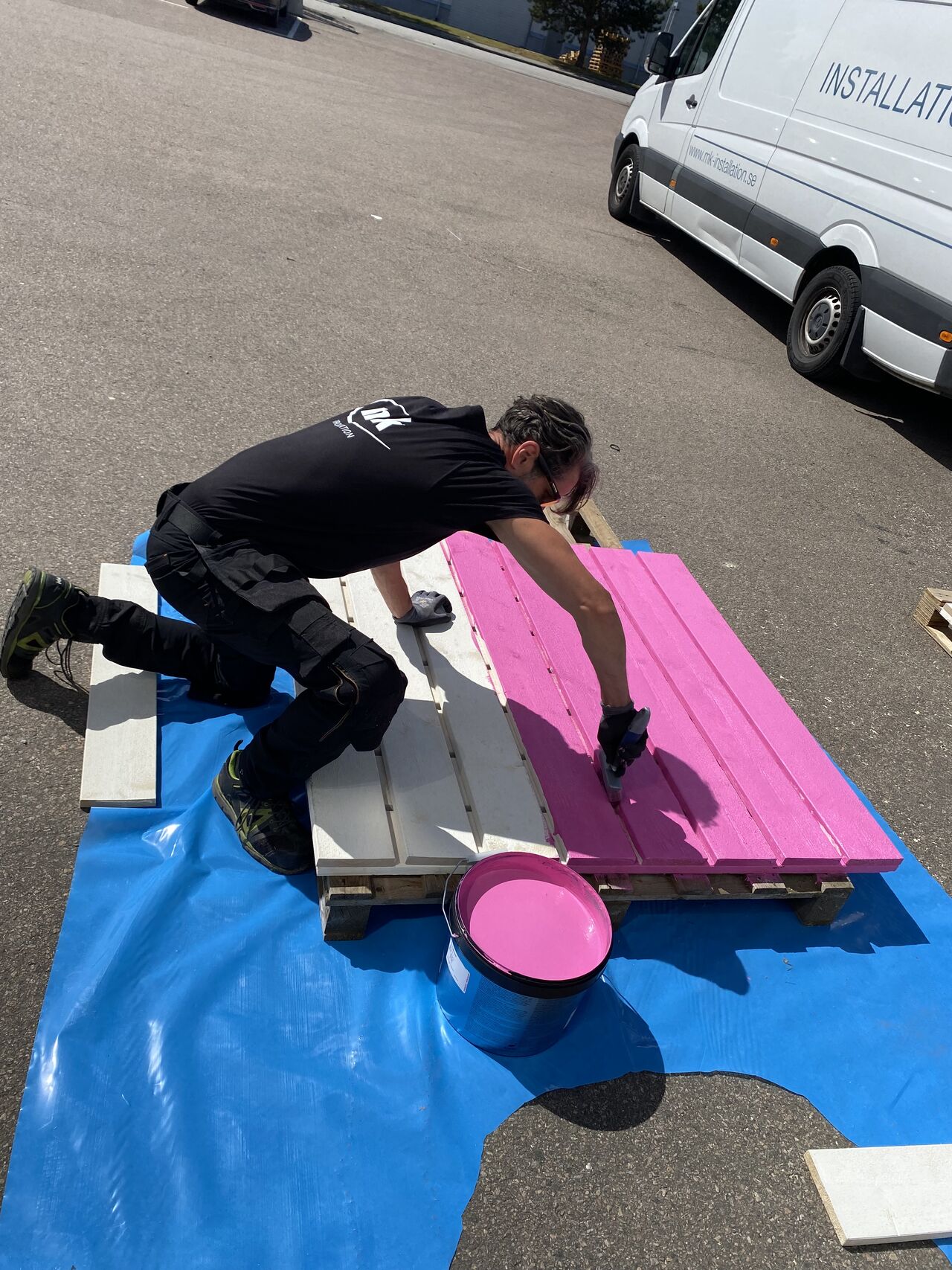 En man målar snickerier i rosa.