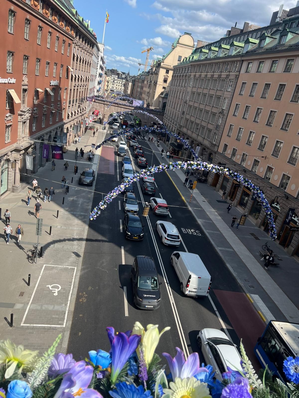 Bågar fyllda med blommar över Kungsgatan i Stockholm.
